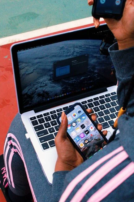Tablette moderne et smartphone montrant du contenu web sur une surface réfléchissante, mettant en avant la technologie et la connectivité.